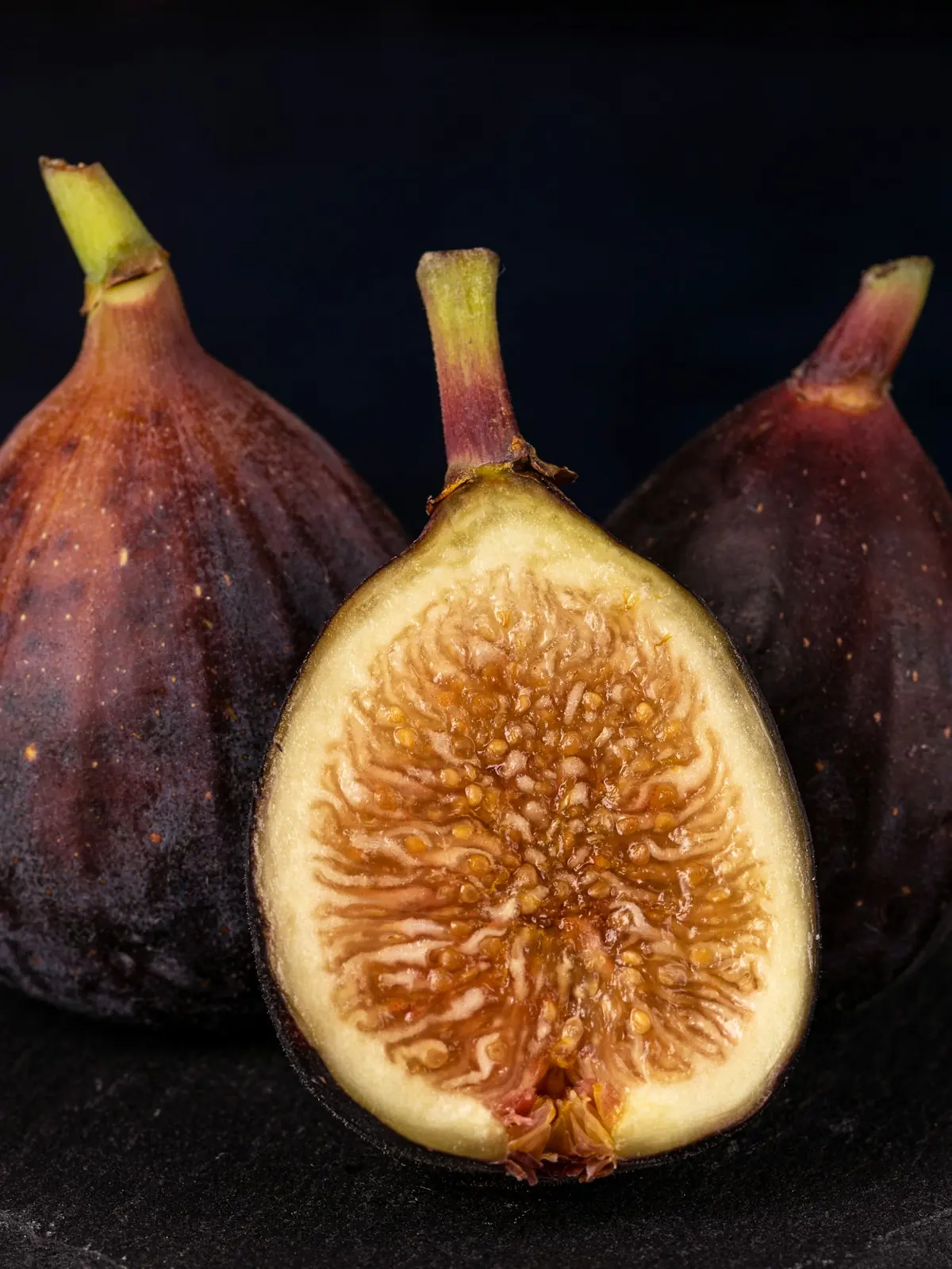 Halved figs on dark wood