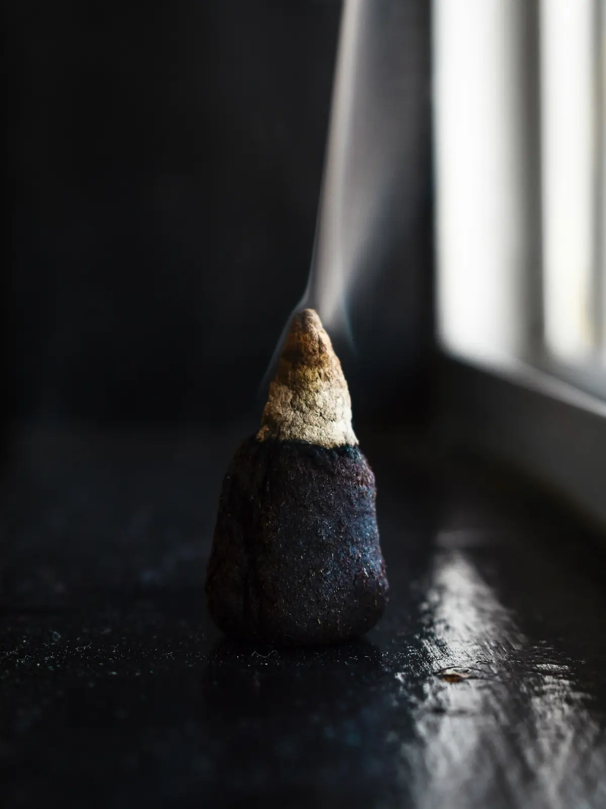 An incense cone smoking beside a window