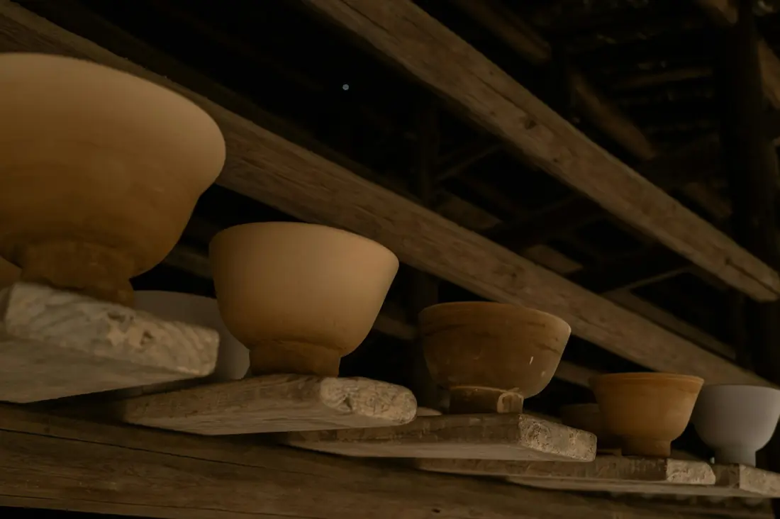 Several ceramic bowls displayed on wooden shelves