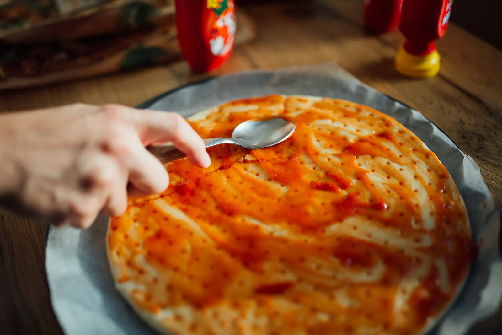 A pizza chef pressing out fresh dough on a floured counter